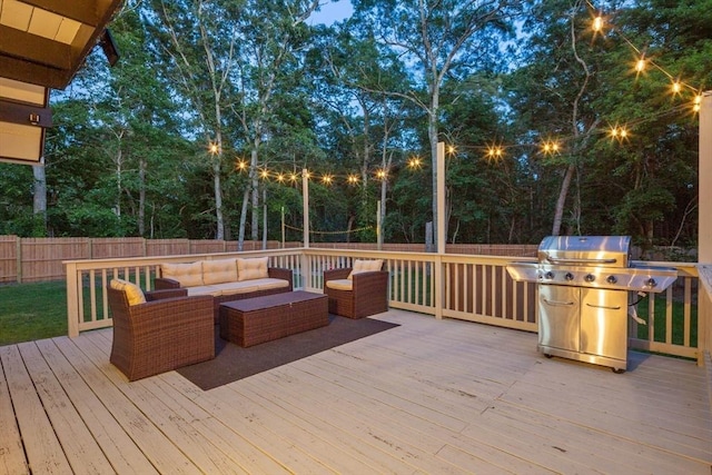 wooden deck featuring a fenced backyard, an outdoor hangout area, and a grill