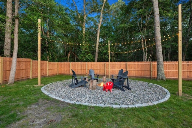 view of yard featuring a fire pit and a fenced backyard
