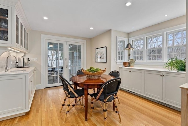 dining room with a wealth of natural light, light wood-type flooring, french doors, and recessed lighting