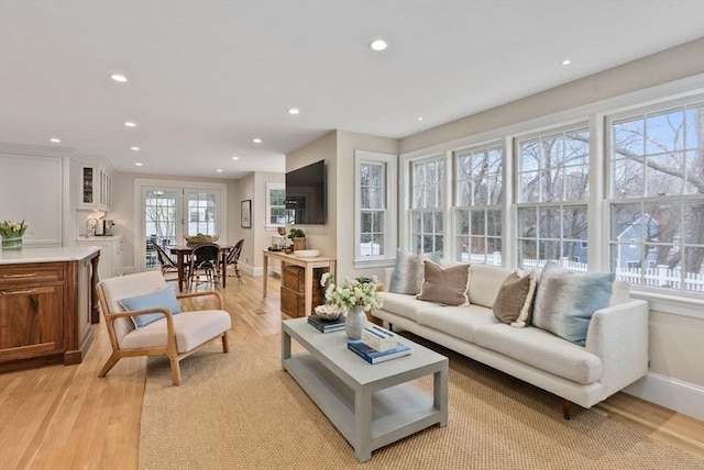 living area featuring light wood-type flooring, baseboards, and recessed lighting