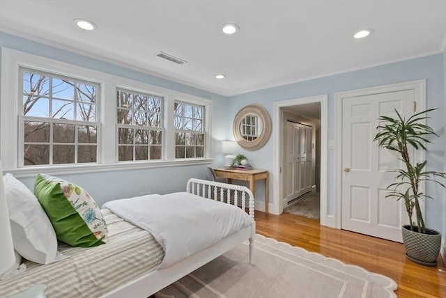 bedroom with wood finished floors, visible vents, and recessed lighting