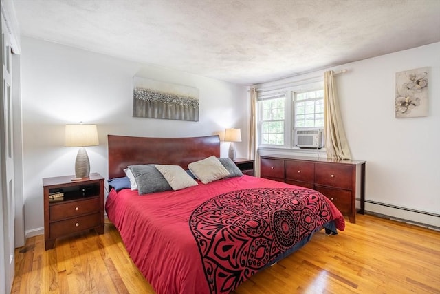 143 Davis St, Northborough, MA 01532 - bedroom featuring wood finished floors, cooling unit, and a baseboard radiator