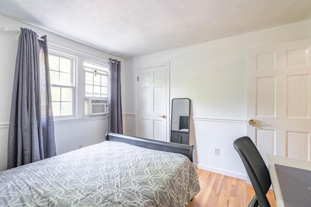 143 Davis St, Northborough, MA 01532 - bedroom with wood finished floors, cooling unit, and baseboards