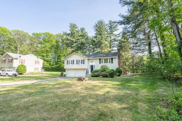 143 Davis St, Northborough, MA 01532 - raised ranch featuring a chimney, an attached garage, asphalt driveway, a front lawn, and view of scattered trees