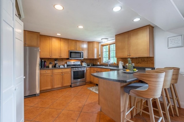 143 Davis St, Northborough, MA 01532 - kitchen with appliances with stainless steel finishes, a peninsula, recessed lighting, dark countertops, and tasteful backsplash