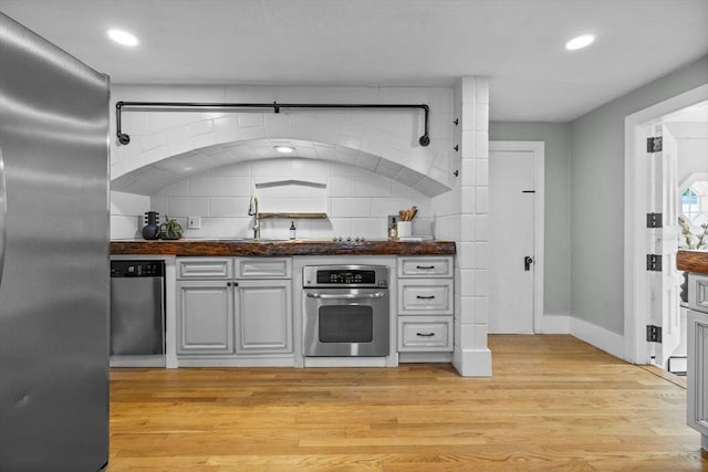 213 Thurston St, Wrentham, MA 02093 - kitchen with appliances with stainless steel finishes, dark countertops, light wood-style flooring, baseboards, and a sink