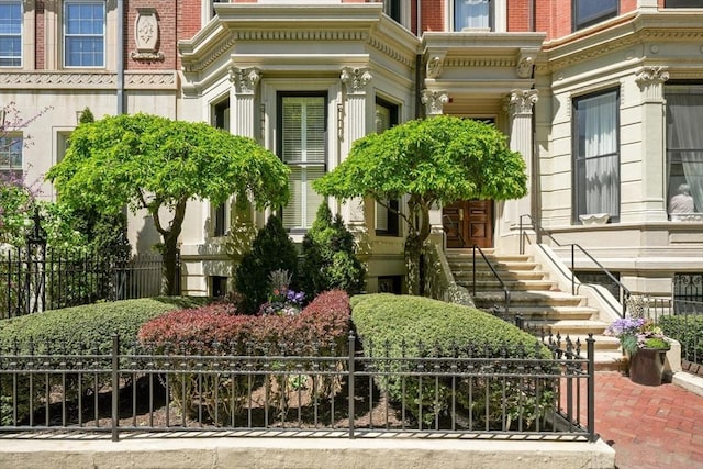 property entrance with brick siding and fence