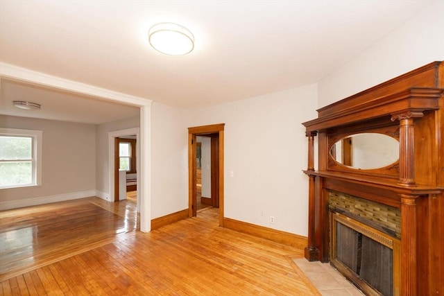 unfurnished living room featuring a fireplace and light hardwood / wood-style flooring