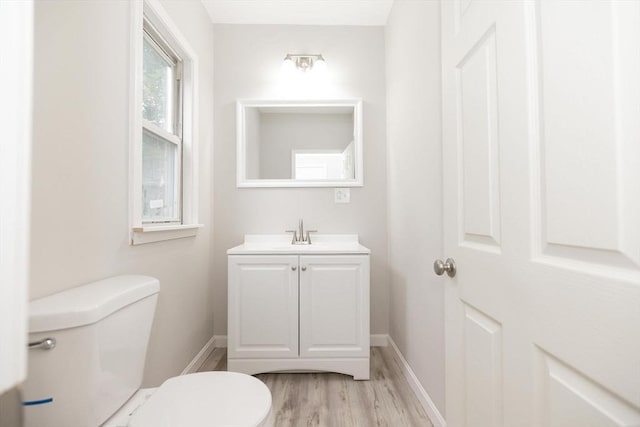 bathroom with hardwood / wood-style flooring, vanity, and toilet