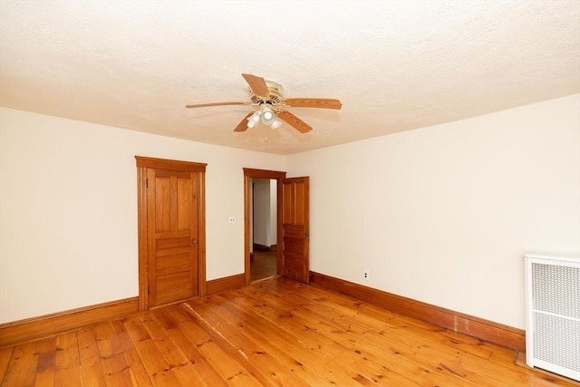 unfurnished room featuring radiator, ceiling fan, and hardwood / wood-style flooring