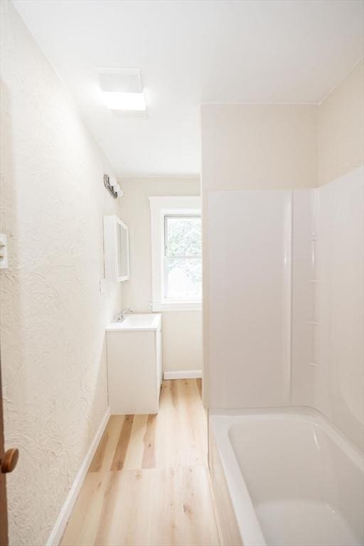 bathroom with vanity, shower / bathtub combination, and hardwood / wood-style flooring