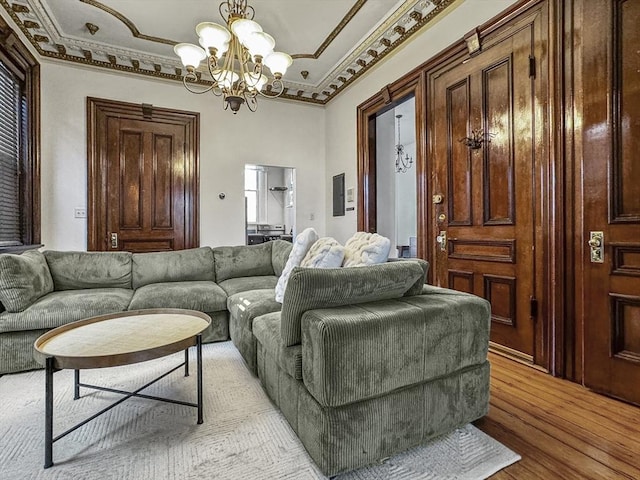 living room featuring ornamental molding, light hardwood / wood-style floors, and a notable chandelier