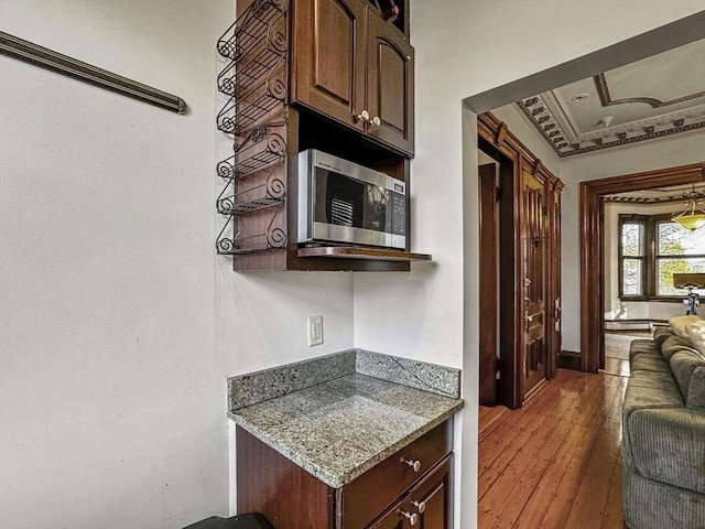 kitchen featuring ornamental molding, dark brown cabinets, and dark hardwood / wood-style floors