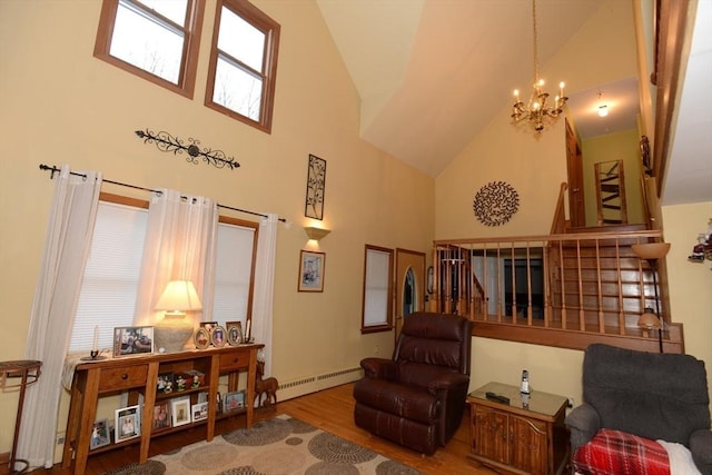 living area featuring hardwood / wood-style floors, high vaulted ceiling, a baseboard heating unit, and a notable chandelier