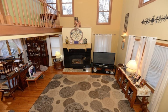 living room featuring hardwood / wood-style flooring, plenty of natural light, and a towering ceiling