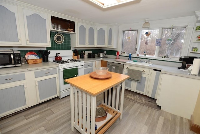 kitchen with white cabinetry, sink, appliances with stainless steel finishes, and light hardwood / wood-style flooring