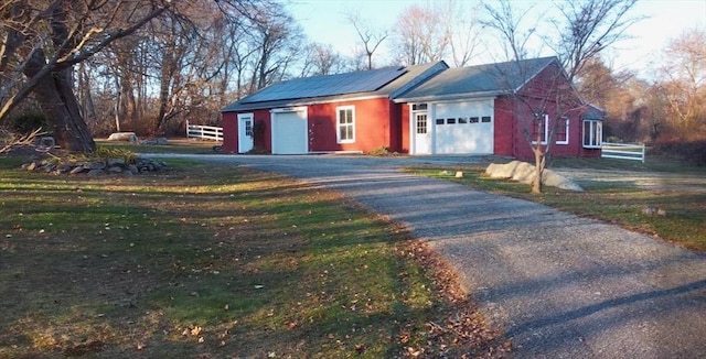 view of front of property with solar panels and a garage