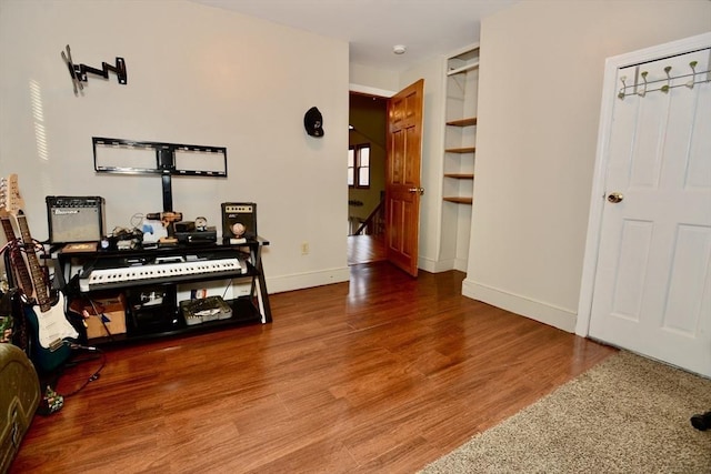 corridor featuring hardwood / wood-style floors and built in shelves