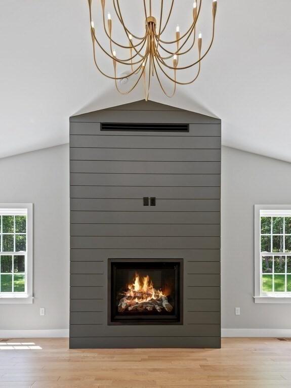 128 Old Southbridge Rd, Dudley, MA 01571 - detailed view of wood finished floors, a chandelier, and a large fireplace