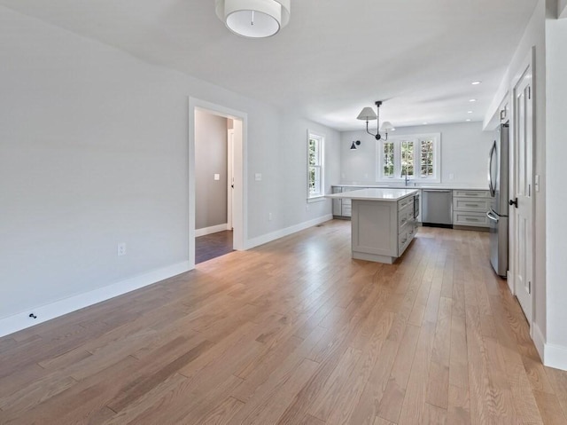 128 Old Southbridge Rd, Dudley, MA 01571 - kitchen featuring stainless steel appliances, gray cabinetry, a center island, light wood-type flooring, and light countertops