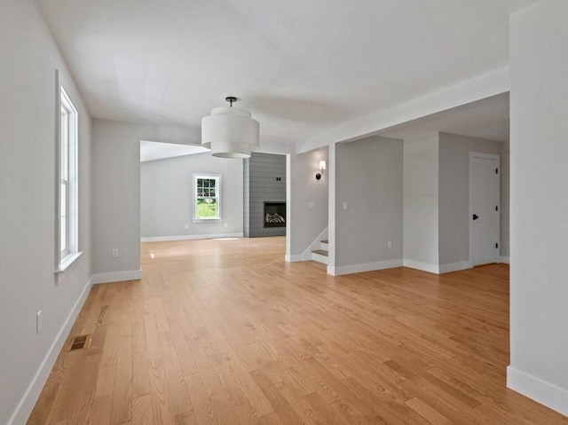 128 Old Southbridge Rd, Dudley, MA 01571 - unfurnished living room with light wood finished floors, stairway, and a large fireplace