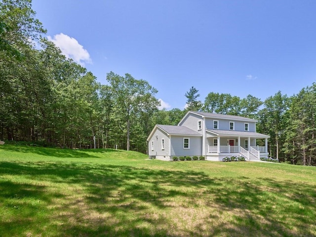 128 Old Southbridge Rd, Dudley, MA 01571 - rear view of house with a porch, a lawn, and a forest view