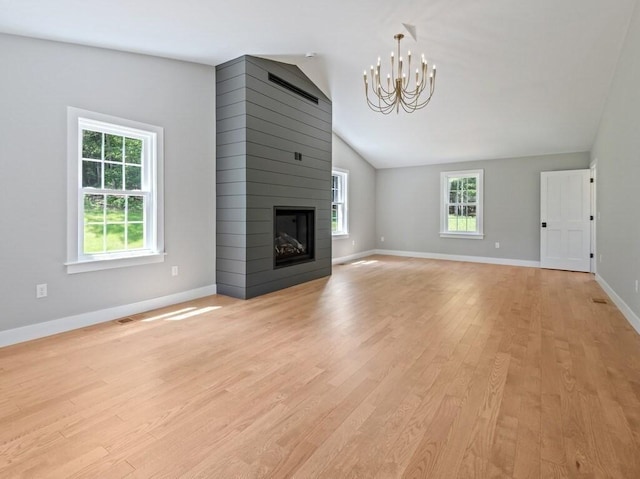 128 Old Southbridge Rd, Dudley, MA 01571 - unfurnished living room with a chandelier, lofted ceiling, light wood-type flooring, and a large fireplace