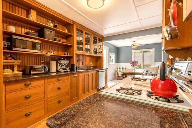 38 Davis St, Plymouth, MA 02360 - kitchen featuring stainless steel appliances, open shelves, a sink, wainscoting, and brown cabinets
