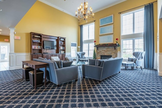 21 Cielo Dr, Dover, NH 03820 - carpeted living room with a towering ceiling, decorative columns, a stone fireplace, a chandelier, and crown molding