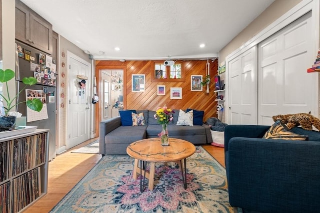 living room featuring light hardwood / wood-style flooring and wood walls