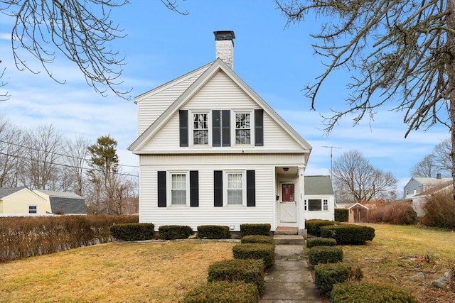 view of front of home with a front yard and a chimney