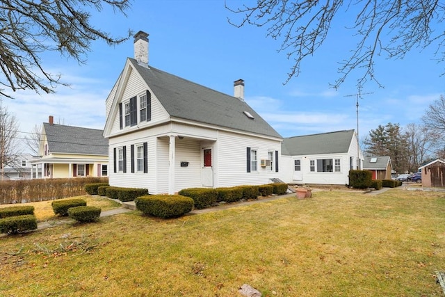 rear view of property with a chimney and a yard