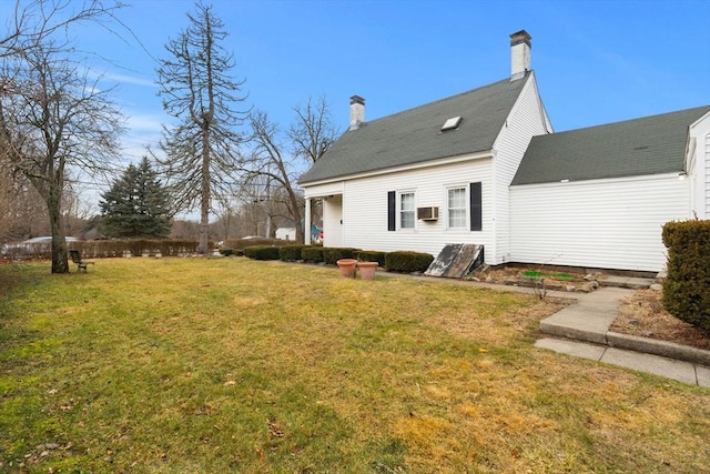 rear view of house with a chimney and a yard