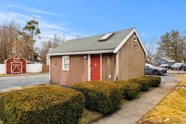 view of outbuilding featuring an outdoor structure and fence