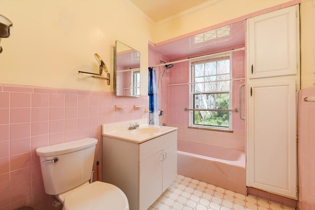 bathroom with ornamental molding, toilet, tile walls, washtub / shower combination, and tile patterned floors