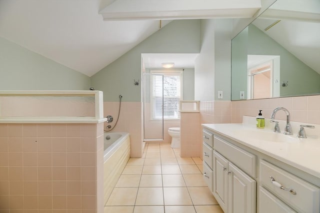 full bathroom with tile patterned floors, lofted ceiling, toilet, and tile walls