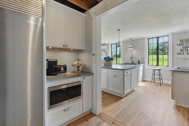 4 Porter St, Granby, MA 01033 - kitchen with appliances with stainless steel finishes, light wood-style floors, white cabinets, and dark countertops