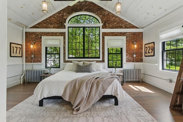 4 Porter St, Granby, MA 01033 - bedroom with radiator, vaulted ceiling, brick wall, a wainscoted wall, and wood finished floors