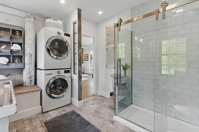 4 Porter St, Granby, MA 01033 - laundry area with estacked washer and dryer, light wood-type flooring, recessed lighting, baseboards, and a barn door