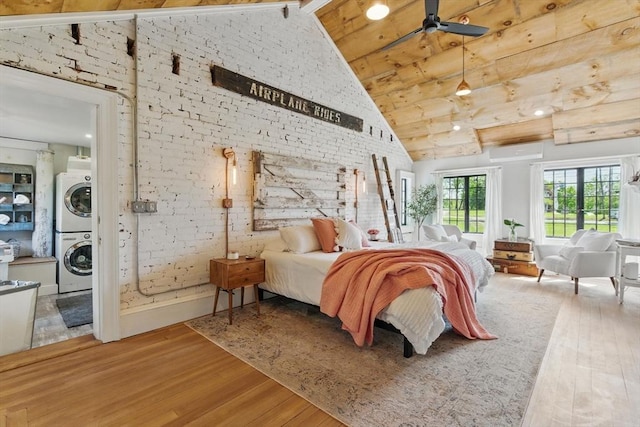 4 Porter St, Granby, MA 01033 - bedroom with estacked washer and dryer, high vaulted ceiling, wood finished floors, brick wall, and beam ceiling