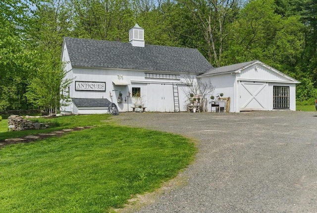 4 Porter St, Granby, MA 01033 - view of front facade featuring roof with shingles, a garage, a front lawn, an outbuilding, and a chimney