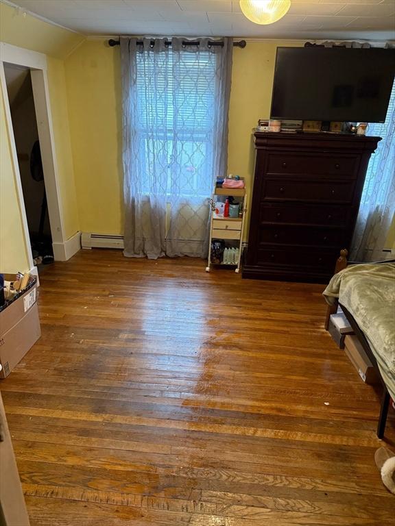 31 Abbott St, Lowell, MA 01852 - bedroom featuring wood finished floors, a baseboard heating unit, and lofted ceiling