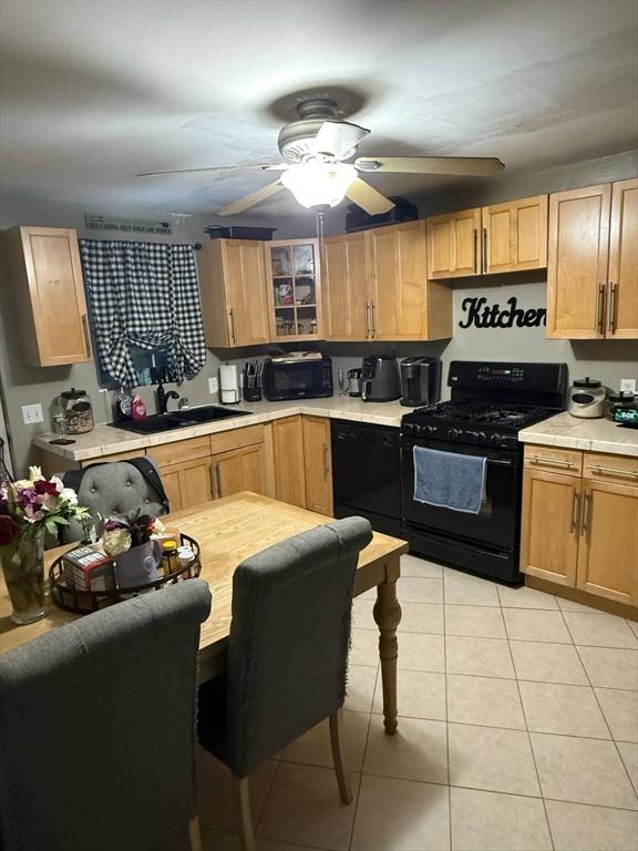31 Abbott St, Lowell, MA 01852 - kitchen featuring black appliances, light tile patterned flooring, light brown cabinets, tile counters, and a ceiling fan