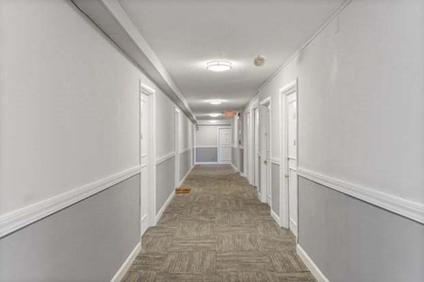 corridor featuring dark carpet