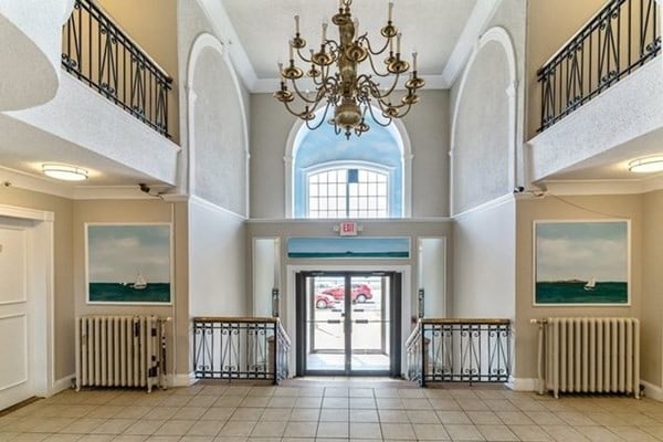 foyer featuring ornamental molding, a chandelier, and radiator