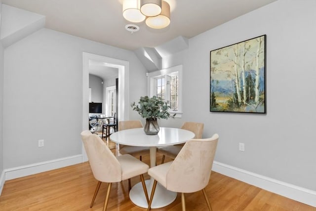 dining room featuring wood finished floors, visible vents, and baseboards