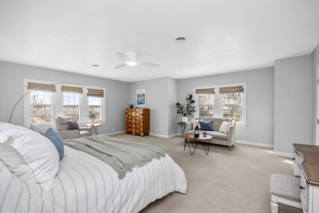 bedroom featuring baseboards, multiple windows, visible vents, and light colored carpet