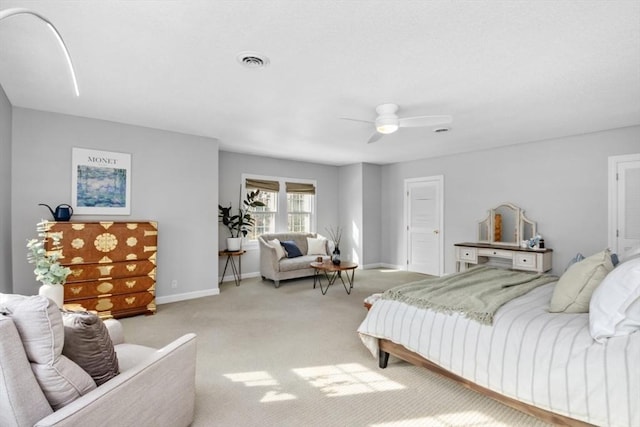 bedroom with light carpet, ceiling fan, visible vents, and baseboards