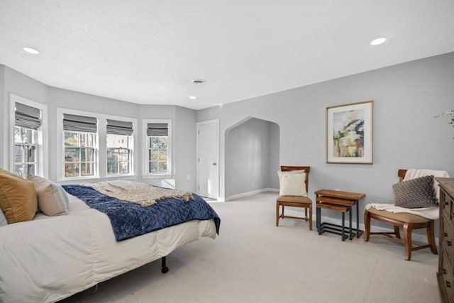 bedroom with arched walkways, recessed lighting, visible vents, light carpet, and baseboards