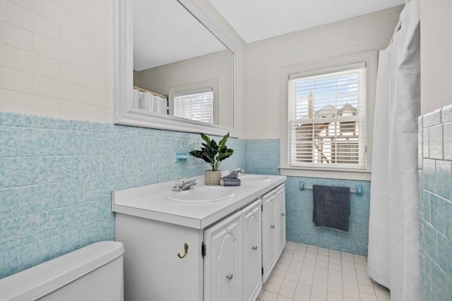 full bathroom featuring a sink, tile walls, and a healthy amount of sunlight